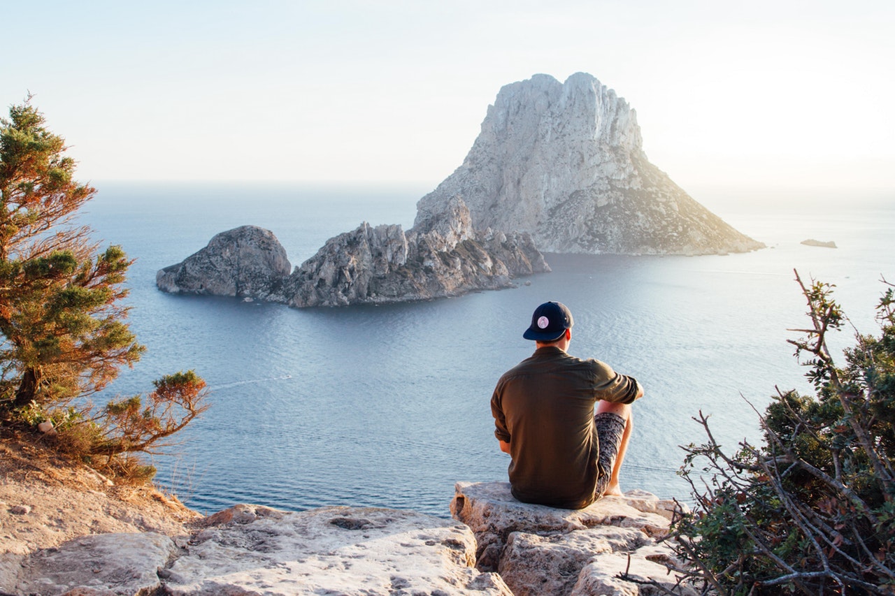 Man sitting on rock in tropical location