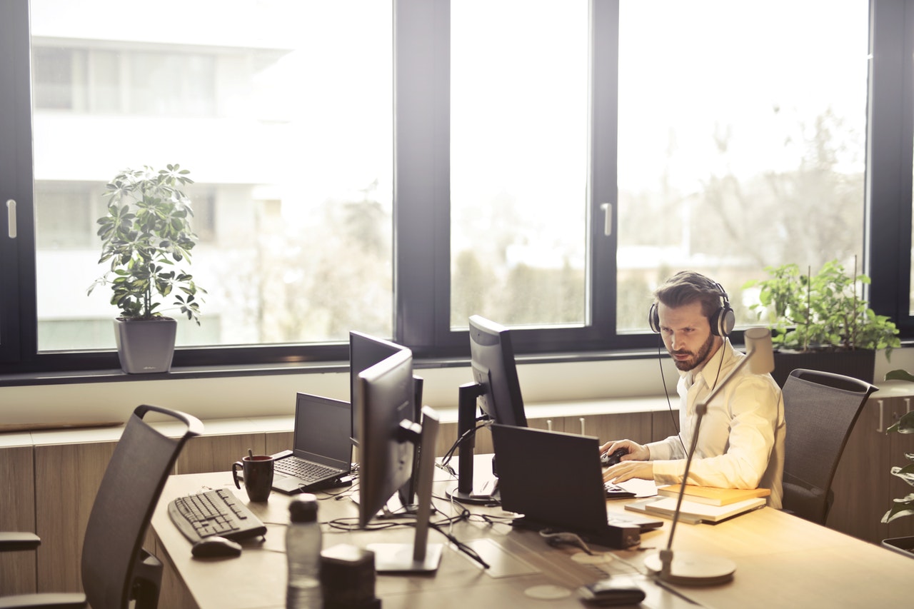 man working at his desk wearing headphones