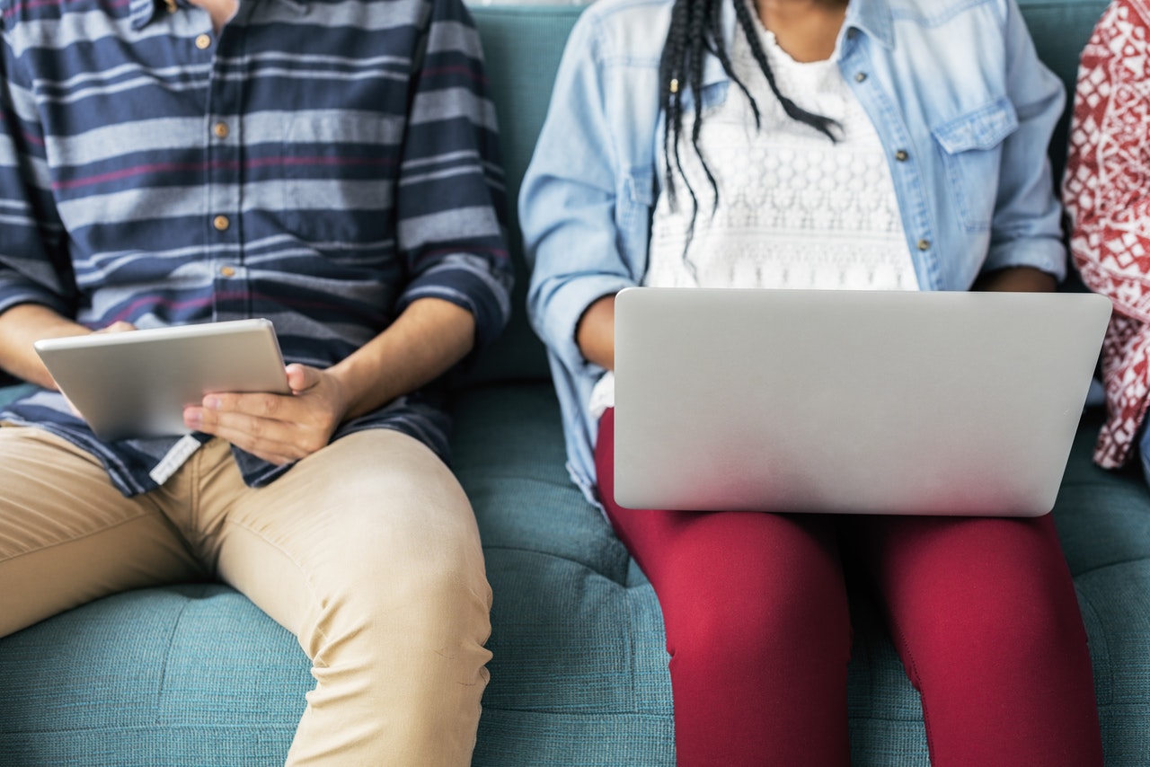 two people sitting with their laptops writing cover letters